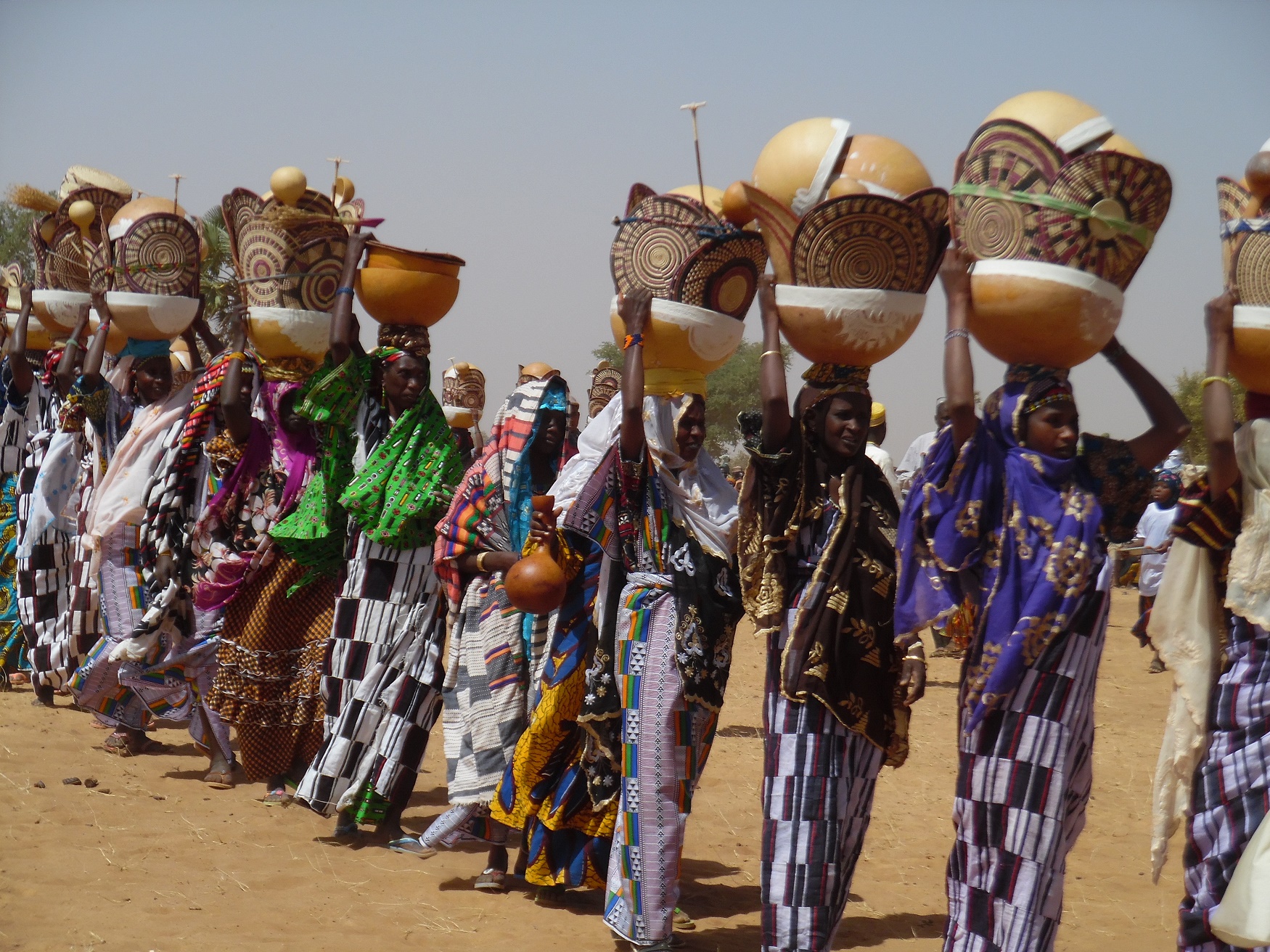 Femmes peules portant calebasses et vanneries décorées lors de la fête pastorale
