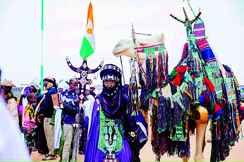 Chameau paré de tissages colorés et cavalier en tenue touarègue lors des fêtes pastorales